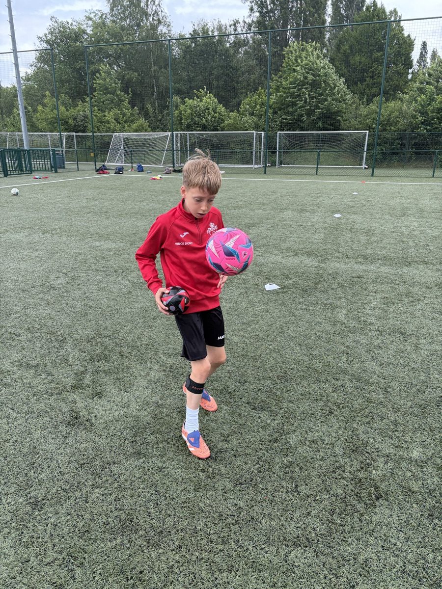 Speler van Rise Academy met ballen op het veld